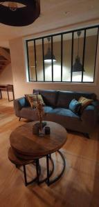 a living room with a couch and a coffee table at Le Relais des Imprimeurs in Bouillon