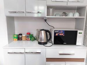 uma cozinha com comodidades para preparar café e um micro-ondas em Las Dalias em Cusco