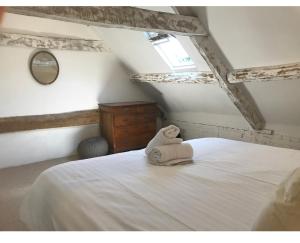 una camera da letto con un letto e un asciugamano sopra di Manor House Mews rustic Stable Conversion a Dorchester