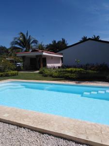 a blue swimming pool in front of a house at Villa Sueño Potrero in Potrero