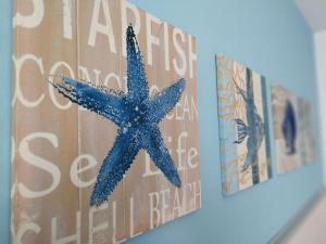 uma estrela-do-mar azul pendurada numa parede ao lado de dois cartazes em Tenuta Aletheia B&B em Alliste