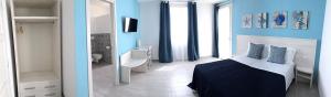 um quarto com paredes azuis e uma cama e um espelho em Tenuta Aletheia B&B em Alliste