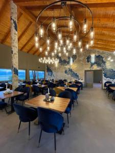 a dining room with tables and chairs and a chandelier at Pensiunea Casa Buna in Gîrbova
