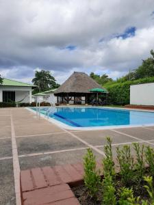 a pool with a gazebo next to a building at Cabañas LLano Lindo Apiay in Villavicencio