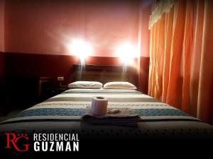 una camera d'albergo con un letto con una tazza sopra di Residencial Guzmán 1 a Yacuiba