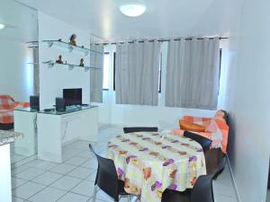 Habitación con mesa, sillas y cocina. en Apartamento Vernazza Aconchegante, en Maceió