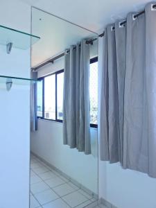 espejo en un baño con cortinas en una habitación en Apartamento Vernazza Aconchegante en Maceió