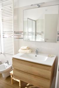 La salle de bains est pourvue d'un lavabo, d'un miroir et de toilettes. dans l'établissement APPARTAMENTO NONNA SILVANA, à Atessa