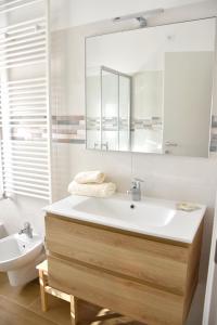 a bathroom with a sink and a mirror and a toilet at Casa Vacanze APPARTAMENTO NONNA SILVANA in Atessa