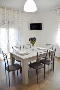 einen Esstisch mit Stühlen und eine weiße Wand in der Unterkunft APPARTAMENTO NONNA SILVANA in Atessa