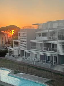 un edificio con piscina frente a la puesta de sol en A CASA DI TATO, en Calambrone