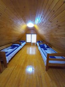 - une chambre avec 3 lits dans une cabane en bois dans l'établissement Hobby Vendégház, à Kiskunmajsa