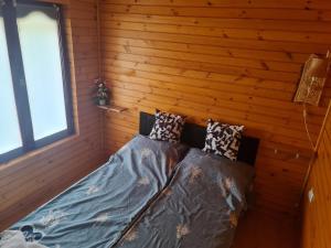 a bedroom with a bed in a wooden wall at Hobby Vendégház in Kiskunmajsa +33 photos