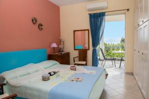 a bedroom with a bed with a view of a balcony at Beachfront Villa Samantha's Paradise in Kivérion
