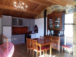 - une cuisine avec une table et des chaises en bois dans l'établissement Casa do Pátio e Casa da Serra, à Castanheira de Pêra