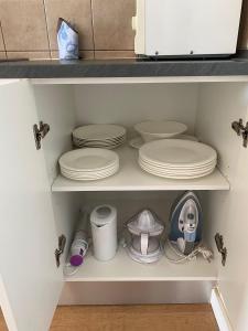 un armario con platos y otros utensilios de cocina en Apartamento Bellavista en Cala'n Bosch