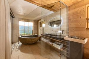 斯拉德明的住宿－奧地利阿爾姆威特酒店，一间带大浴缸和水槽的浴室