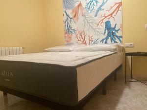een bed in een kamer met een schilderij aan de muur bij Agradable Adosado 3 plantas Altea in Altea