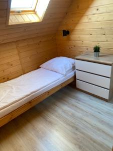 Cama en habitación de madera con ventana en Morza szum en Karwia