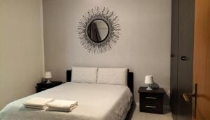 una camera da letto con un letto con uno specchio sul muro di ROMA HOME a Trento