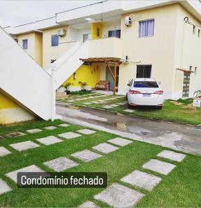 un coche blanco estacionado frente a un edificio en Praia dos Corais - Bahia, en Coroa Vermelha