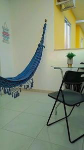 a chair and a hammock in a room at Praia dos Corais - Bahia in Coroa Vermelha
