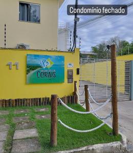 ein gelbes Gebäude mit einem Schild, das Korallen liest in der Unterkunft Praia dos Corais - Bahia in Coroa Vermelha