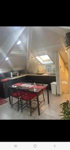 a kitchen with a table and two red chairs at Appartement T LUXE in Pierrefitte-sur-Seine