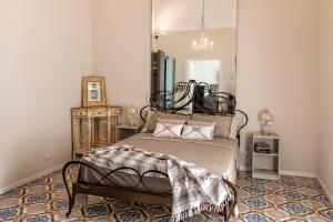 a bedroom with a bed and a mirror at Cave Bianche Apartments in Favignana