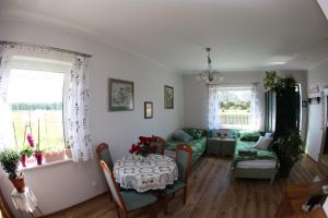ein Wohnzimmer mit einem Tisch und einem Sofa in der Unterkunft Zielona Przystań in Boruja