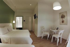 a bedroom with a bed and a table and chairs at B&B Medinblu in Reggio di Calabria