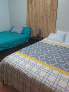 a room with two beds and a window with a curtain at B. J. & M SERVICE in Iquitos