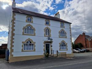 un gran edificio blanco con ventanas en una calle en Ty Llew, en Llandysilio