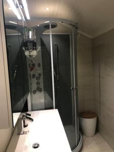 a bathroom with a shower and a sink and a mirror at Stort hus i Porsgrunn sentrum med raskt, pålitelig internett og gratis parkering in Porsgrunn