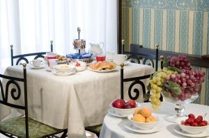 uma mesa com pratos de comida e fruta em Pinto-Storey Hotel em Nápoles