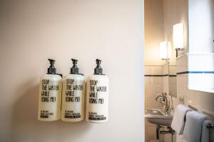 a bathroom with three shampoo bottles on the wall at Gutshaus Zarchlin in Zarchlin