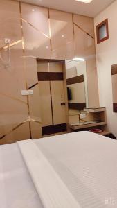 um quarto com uma cama e um espelho grande em SHRADDHA HOTEL em Alīgarh
