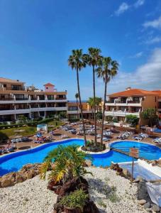 een uitzicht op een resort met een zwembad en palmbomen bij Tu hogar en Tenerife ,Parque Albatros in San Miguel de Abona