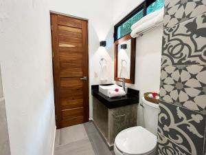 a bathroom with a toilet and a sink at HOTEL KOOKAY VALLADOLID in Valladolid