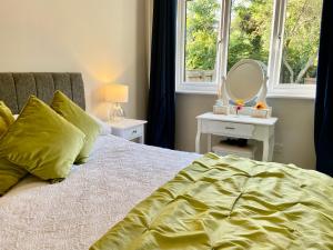 a bedroom with a bed with a mirror and a window at Cosy Bungalow Near Open Countryside in Felixstowe