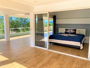 - une chambre avec un lit et un balcon dans l'établissement TAHITI - Raimiti Dream Apartment, à Fa'a'ā
