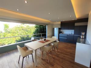 - une cuisine et une salle à manger avec une table et des chaises dans l'établissement TAHITI - Raimiti Dream Apartment, à Fa'a'ā