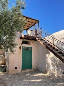 una puerta verde en el lateral de un edificio con una escalera en Chiusa del Curiale - ospitalità in vigna, en Comiso