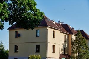a large yellow building with a roof at Apartament ZŁOTE GÓRY - Stronie Śląskie in Stronie Śląskie