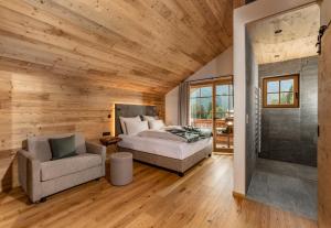 ein Schlafzimmer mit einem Bett und einem Stuhl in der Unterkunft Almwelt Austria in Schladming