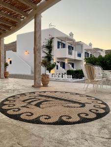 a rug on a patio with chairs and buildings at 'Lindian Myth' Sea View Studios in Lindos