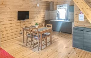 een keuken met een tafel en stoelen en een televisie bij 2 Bedroom Cozy Home In Jaroslawiec in Jarosławiec