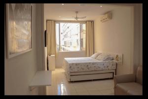 1 dormitorio con cama y ventana en Copacabana Vista Mar Studio, en Río de Janeiro