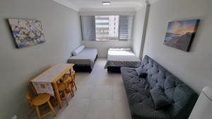 a small living room with a couch and a table at Apartamento kit Praia Grande na Guilhermina Frente Mar in Praia Grande