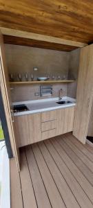 a kitchen with a sink and a wooden floor at Glamping Mirador del Guavio in Ubalá